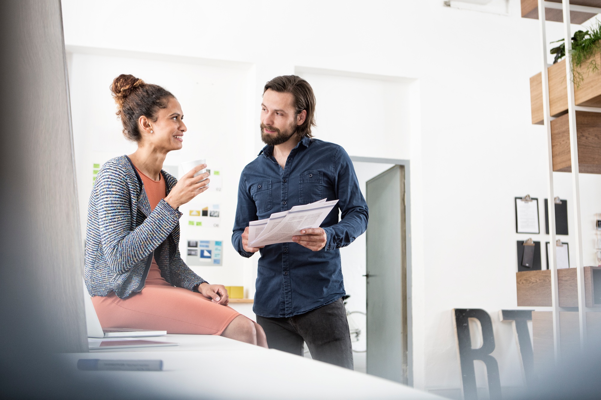Two colleagues discussing papers in office